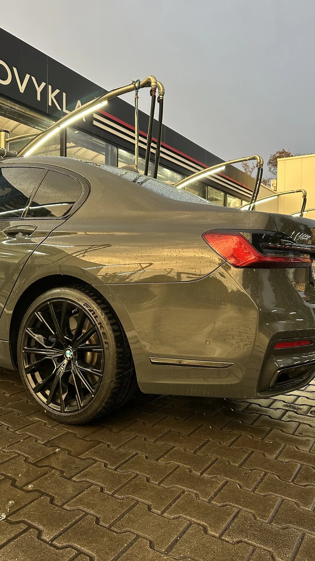 Automobilio galinio žibinto ir kėbulo detalė lyjant lietui.